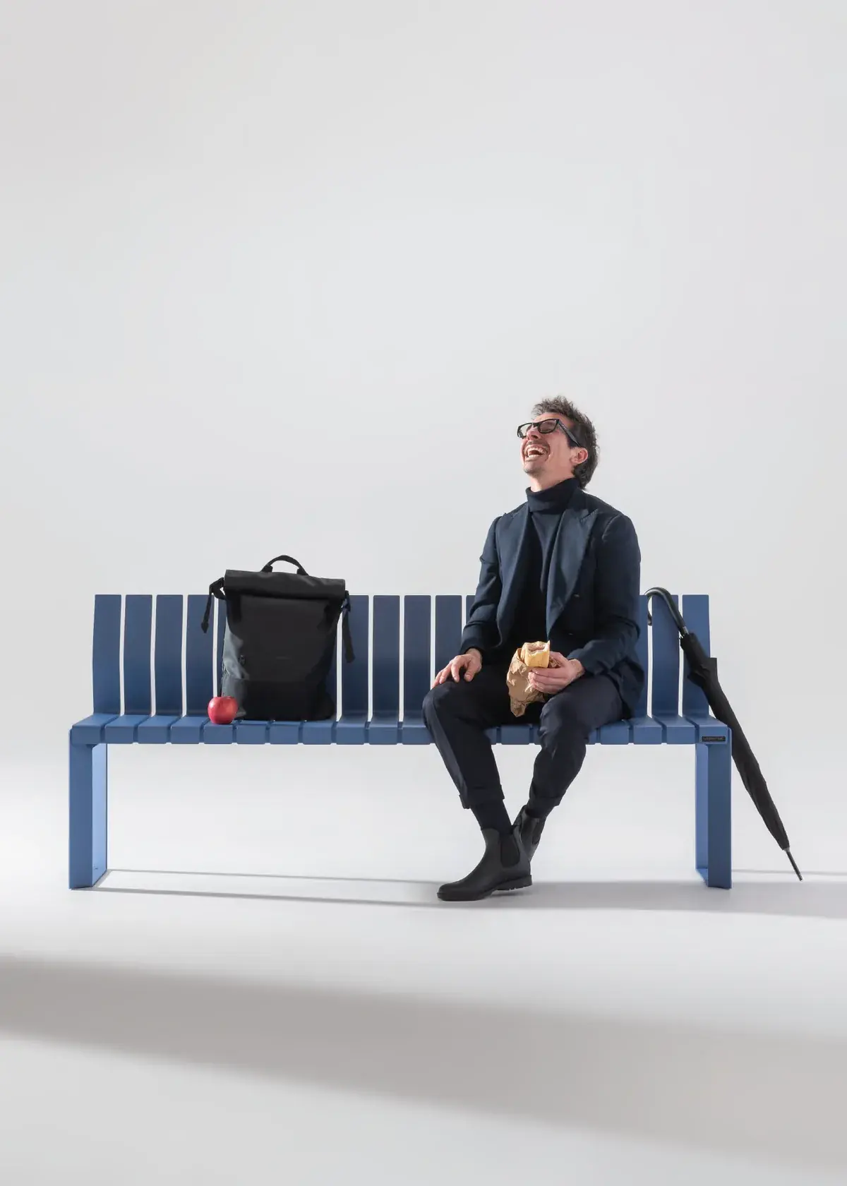 Man seated on a blue Liberty.080 bench